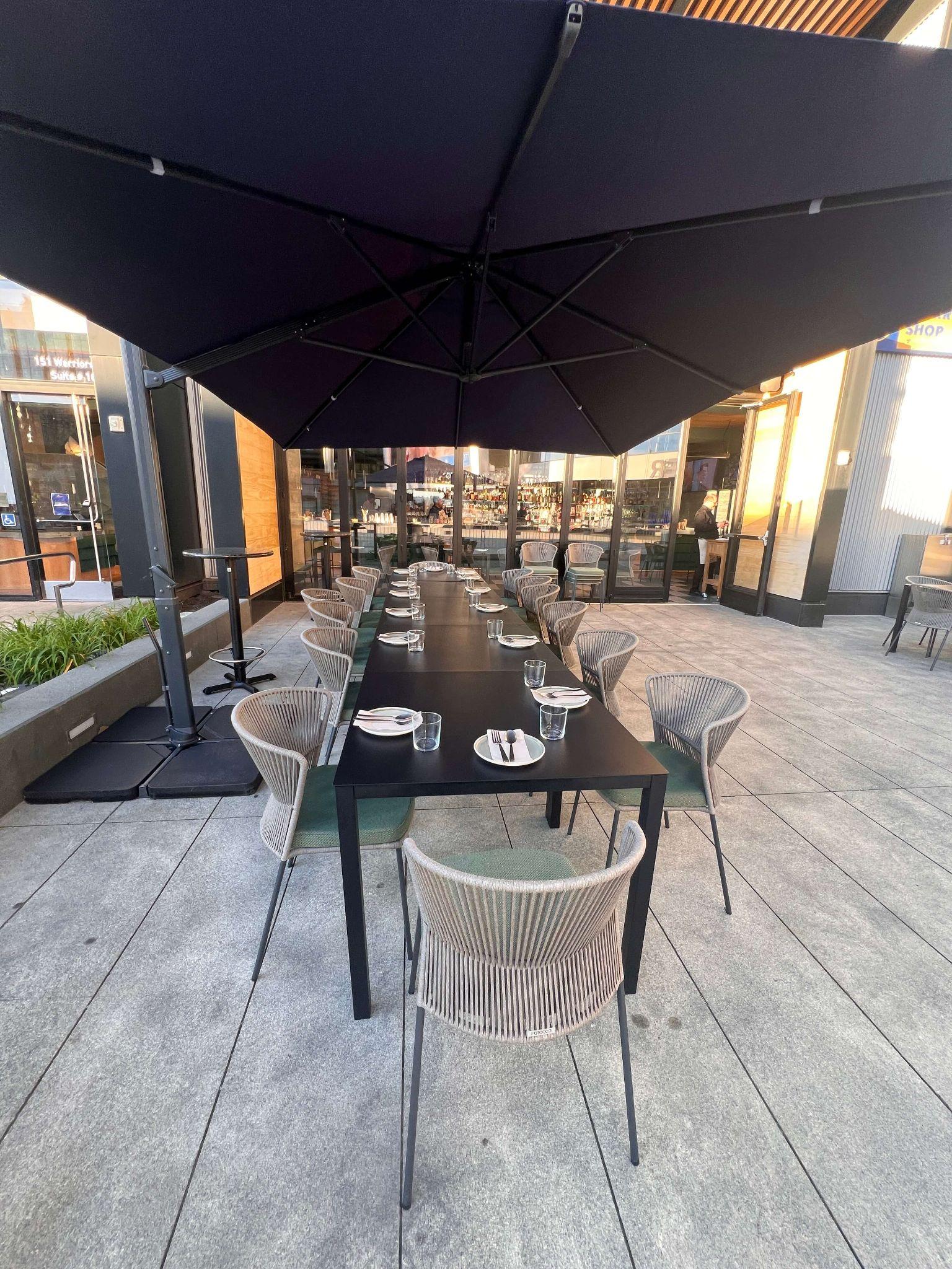 Burma Love Chase Center — long table set for a private dinner on the outdoor patio at dusk