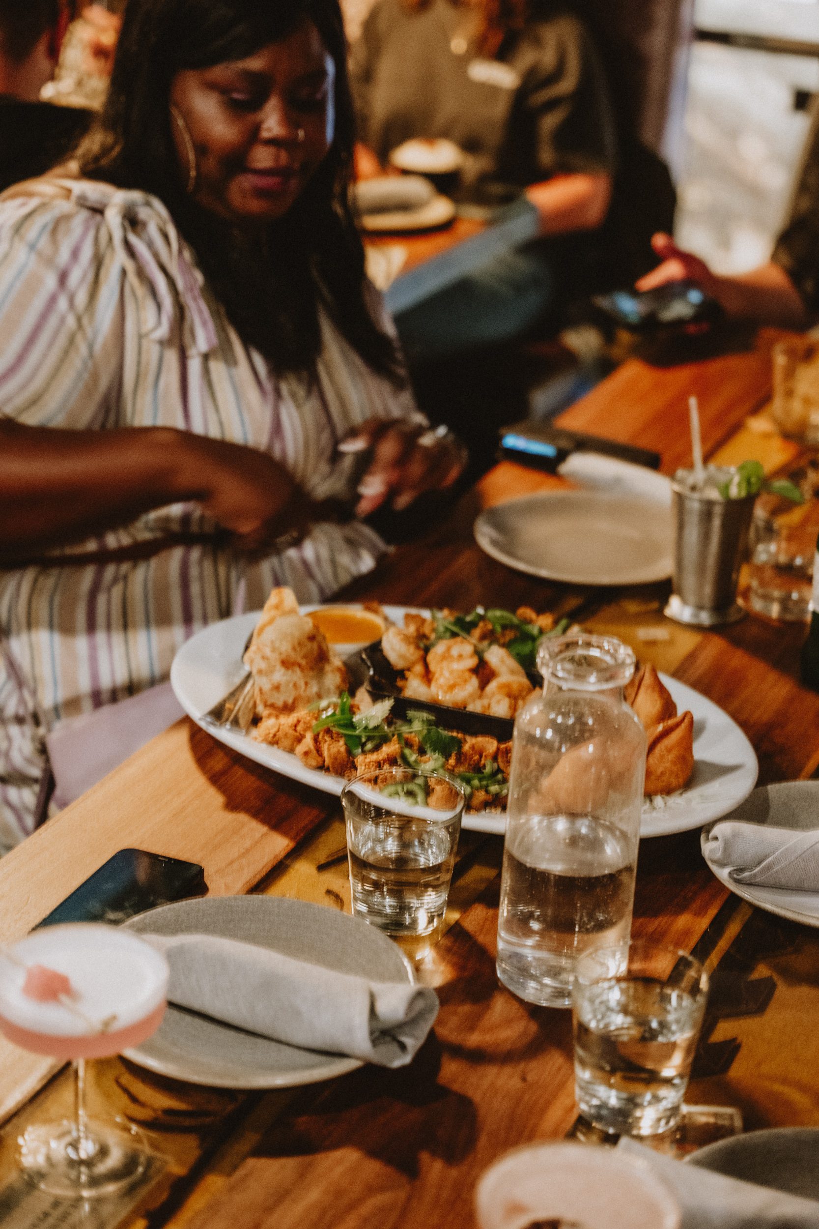 Friends sharing a samusa platter