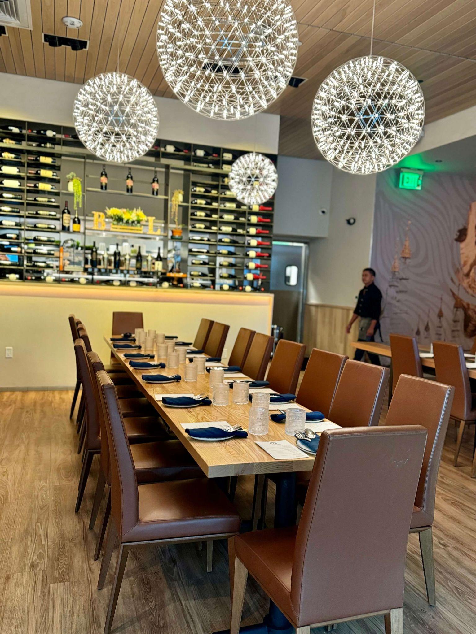 Burma Love Menlo Park — long table set for a group dinner with firework chandeliers and wine bar