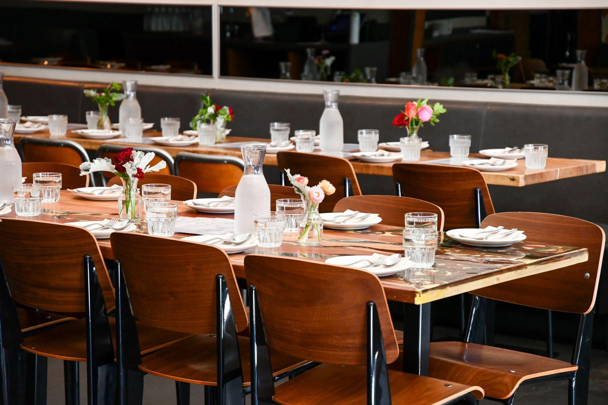 Burma Love Valencia — full dining room set for a buyout with long tables, scallop tile wall, and open kitchen