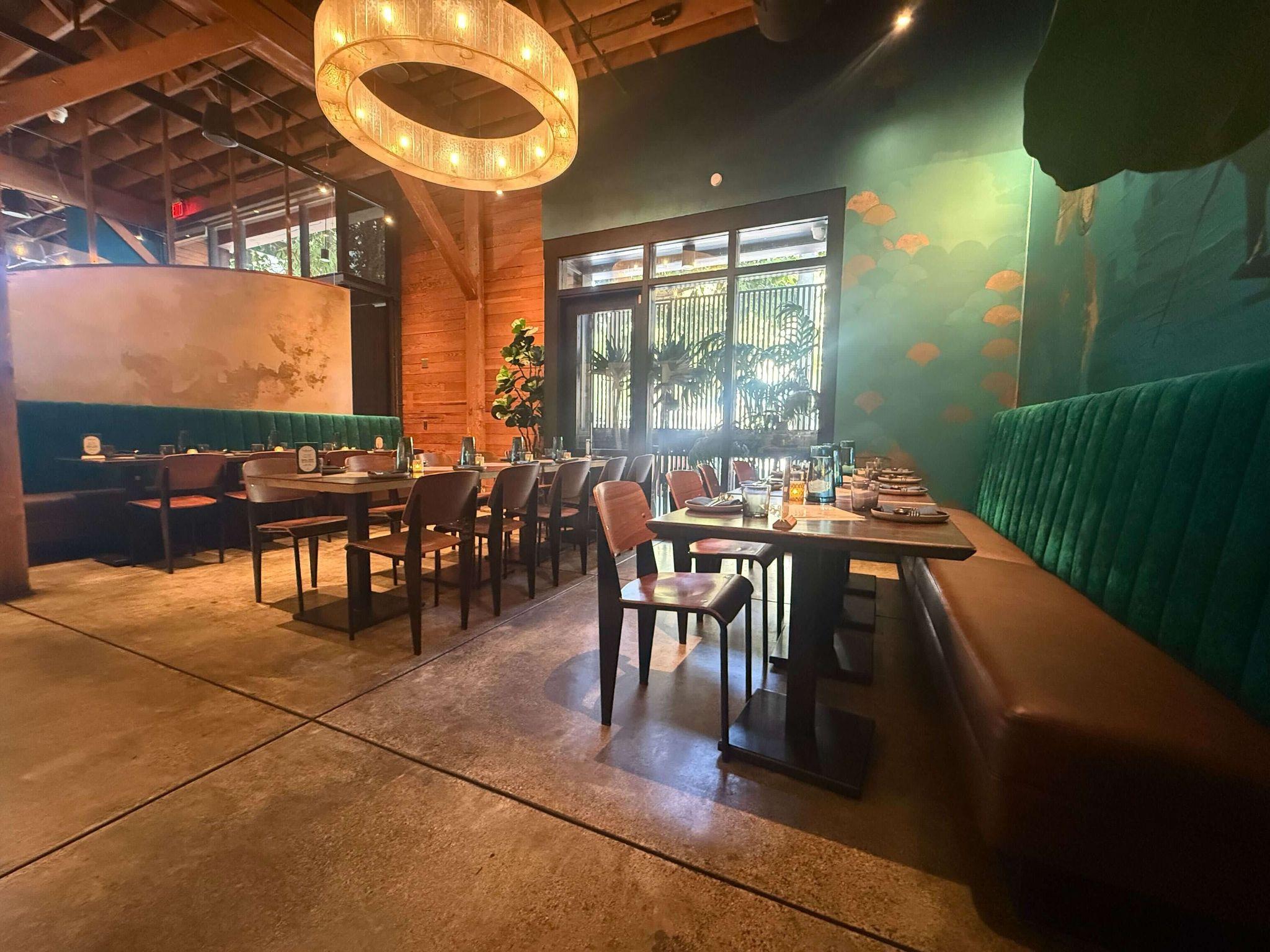 Teakwood East Dining Room — Burma map mural, long table set for a group, natural wood walls and ring chandelier